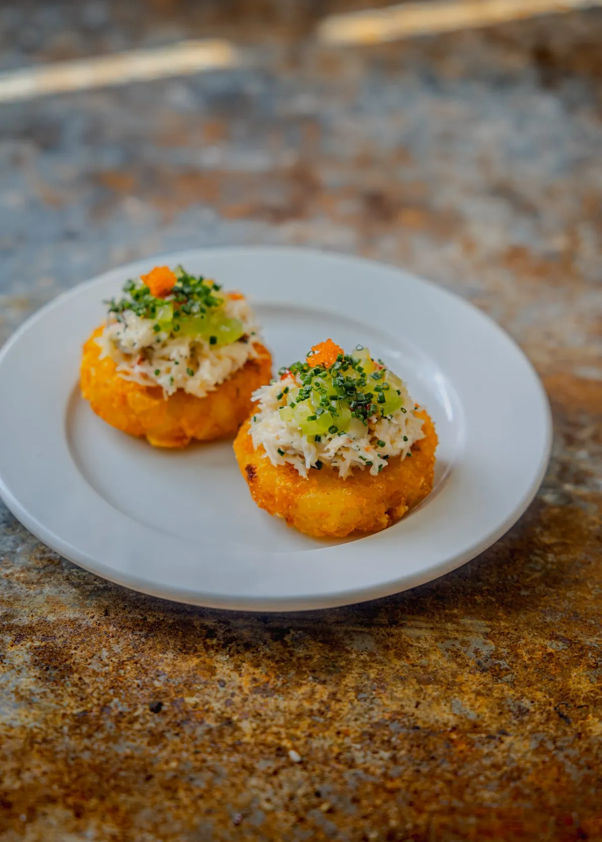 Cornish hand-picked crab on potato rösti with cucumber and sriracha, two on the plate